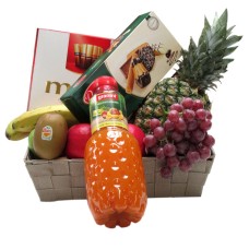 Cesto di frutta con biscotti succhi di frutta e cioccolato
